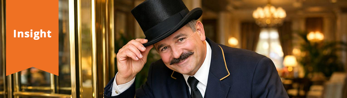 A hotel doorman warmly tips his hat in greeting.