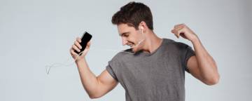 image of a man dancing whilst listening to his smartphone with earphones